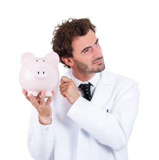 Closeup portrait, health care professional, scientist,  pharmacist, doctor, nurse knocking on piggy bank, listening to see if there is money, isolated on white background. Health care reform