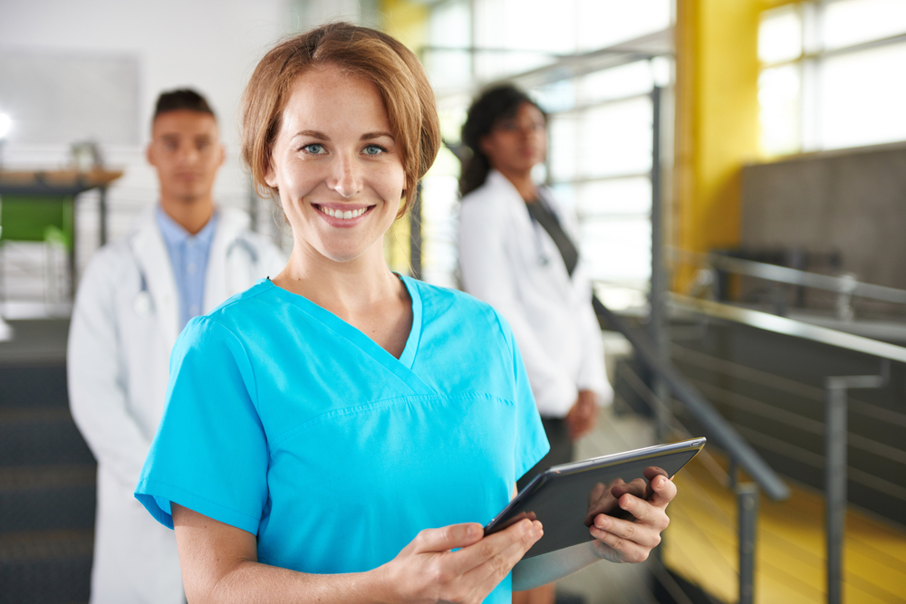 Portrait of a friendly caucasian female doctor and team in bright modern office